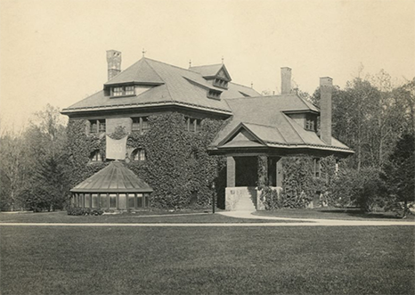 Exterior view of the old gymnasium in Bryn Mawr College. The front of the building is visible. The photograph was taken from the ground in front of the gymnasium. Several trees surround the building.