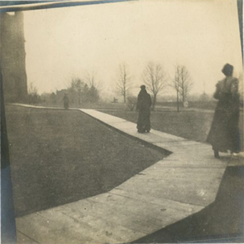 A photograph depicting women walking on a wooden raised walkway.